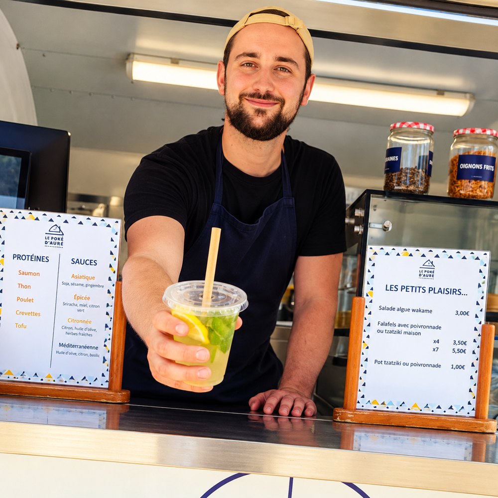 Lucas tend une citronnade maison depuis le comptoir du food truck